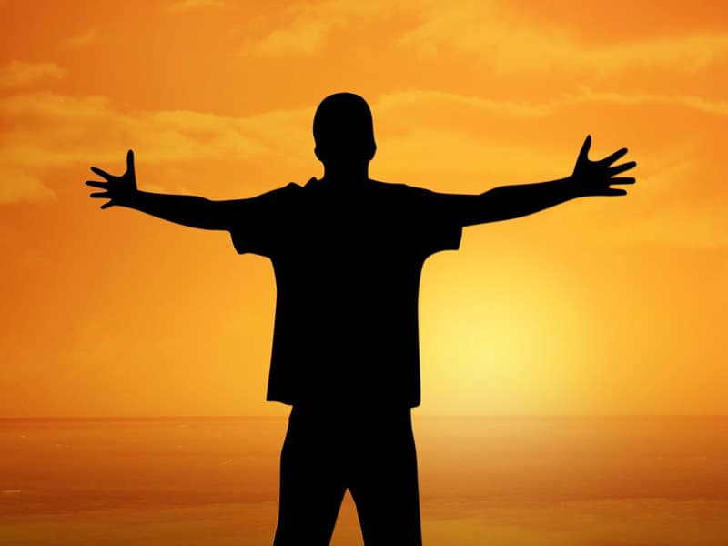 Silhouetted man with arms outstretched to illustrate happy result of using p-shot