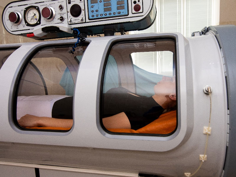 person in a chamber receiving hyperbaric oxygen therapy