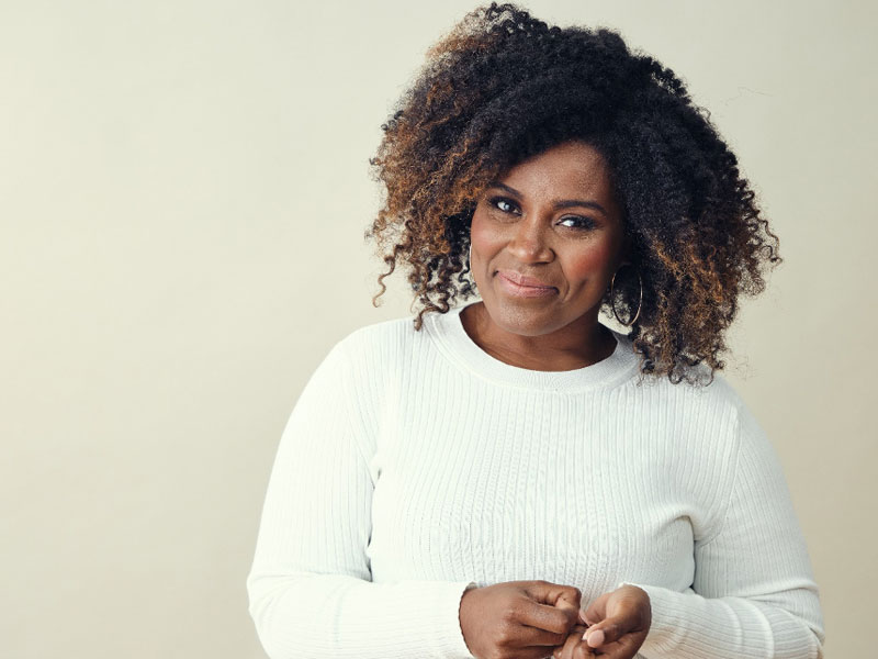 smiling woman looking at camera to illustrate how to balance hormones naturally