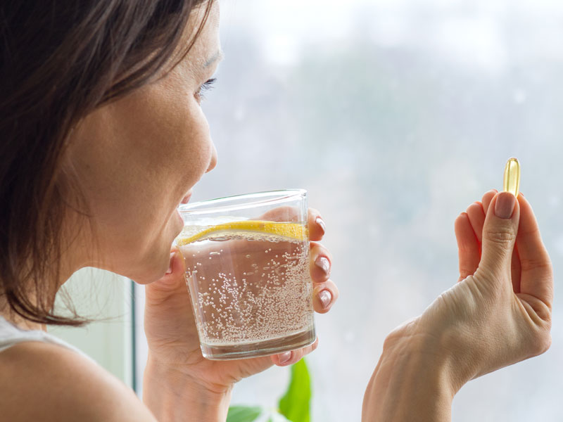 woman taking pill currently on peptide treatment