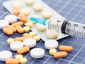 heap of medicine pills and syringe to illustrate treating menopausal symptoms