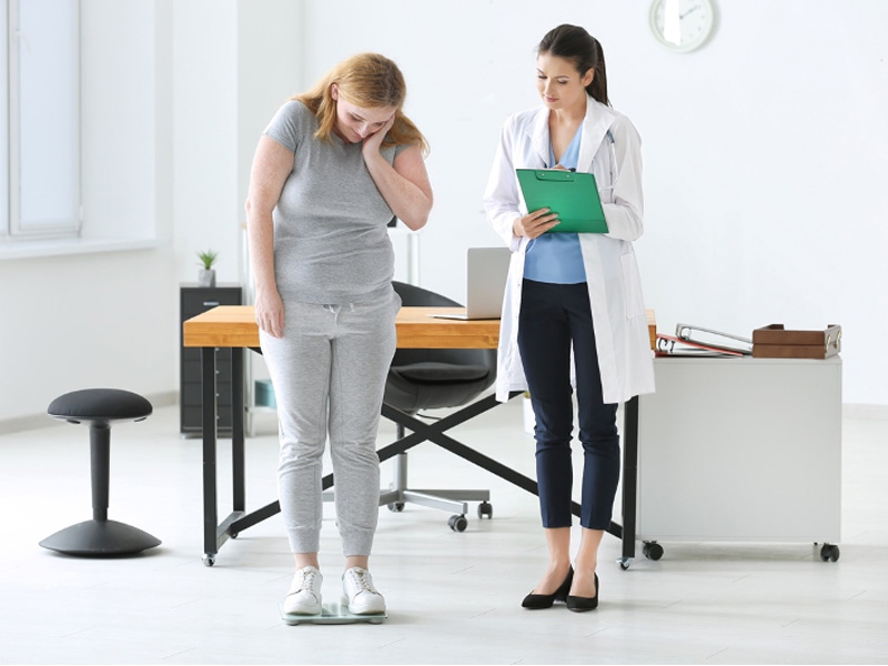 doctor with overweight woman on scales, to illustrate semaglutide for weight loss