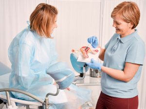 Doctor showing patient a model of reproductive organs to explain types of hysterectomy