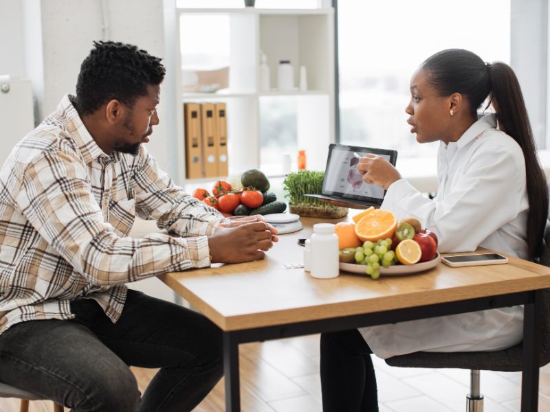 man meets with a certified nutrition counselor to discuss his long term health goals.