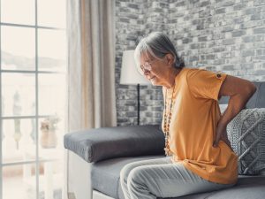 mature woman feeling back to illustrate chronic pain problem