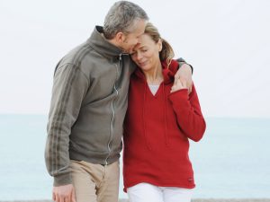 couple hugging on beach to illustrate sexual relations after hysterectomy recovery