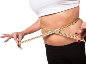 girl measuring waist with tape measure to gauge weight loss