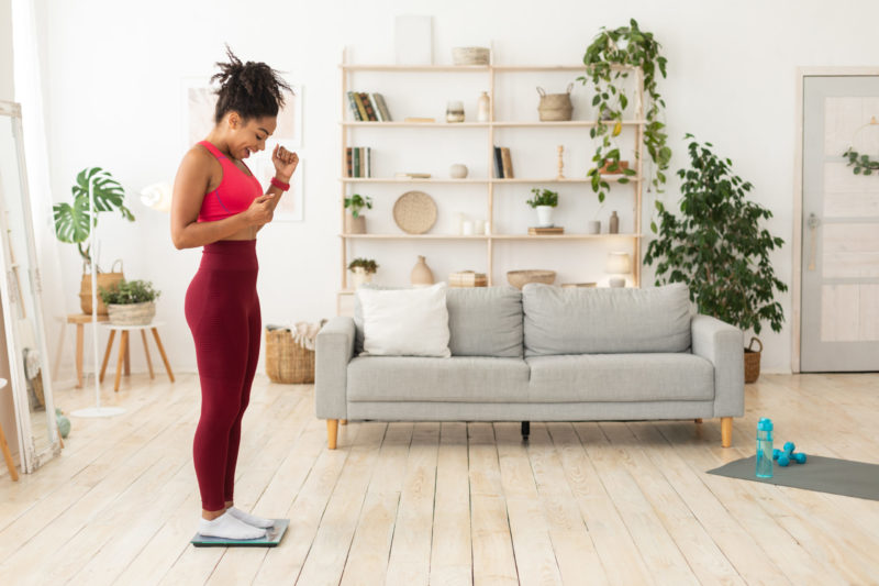 young woman weighing herself, lost weight