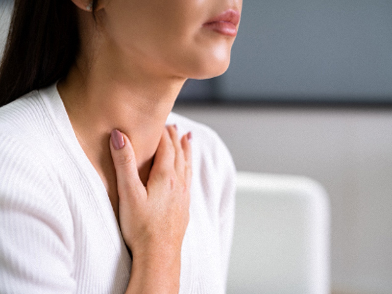 woman holding thyroid area in neck to illustrate a semaglutide and hypothyroidism discussion