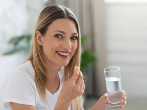woman taking a tablet to illustrate taking calcium and magnesium supplements together