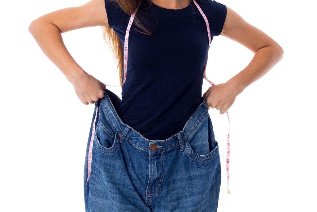 Woman wearing jeans of much bigger size due to weight loss
